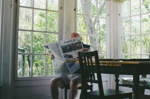 Elderly man reading newspaper