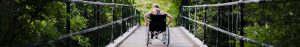 Person crossing a bridge in a wheelchair