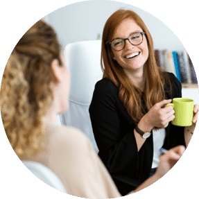 Two women talking and laughing at work