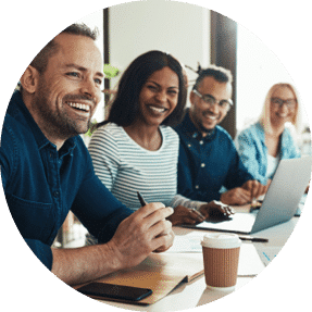 Three colleagues sat in a row in a meeting room and laughing