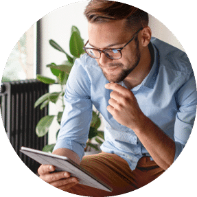 A man looking down to read a tablet and smiling