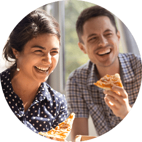 Two colleagues enjoying pizza together at work