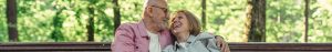 Elderly couple laughing on a bench