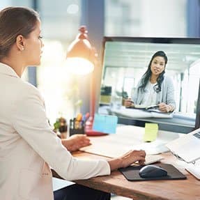 Two colleagues talk via video-conference