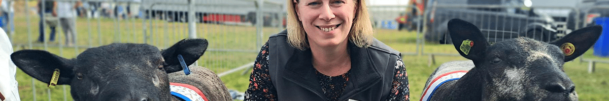 Field Talk Roadshow 11 CW solicitor posing with two prize winning sheep at a county show
