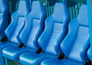 Empty coach and reserves blue bench on a football stadium