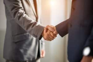 Two businessmen handshake for teamwork of business merger