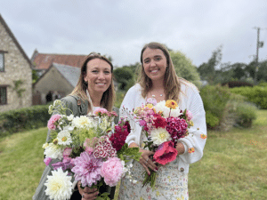 Paige Skudder and Laura Mackain-Bremnerpose with flowers